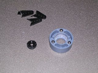 The now-too-small servo bracket and trimmed off pieces and the modified clutch with the center cut out